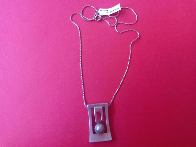 Colgante con cadena de plata con perla gris.