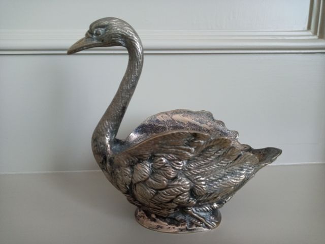 Cisne de metal plateado.