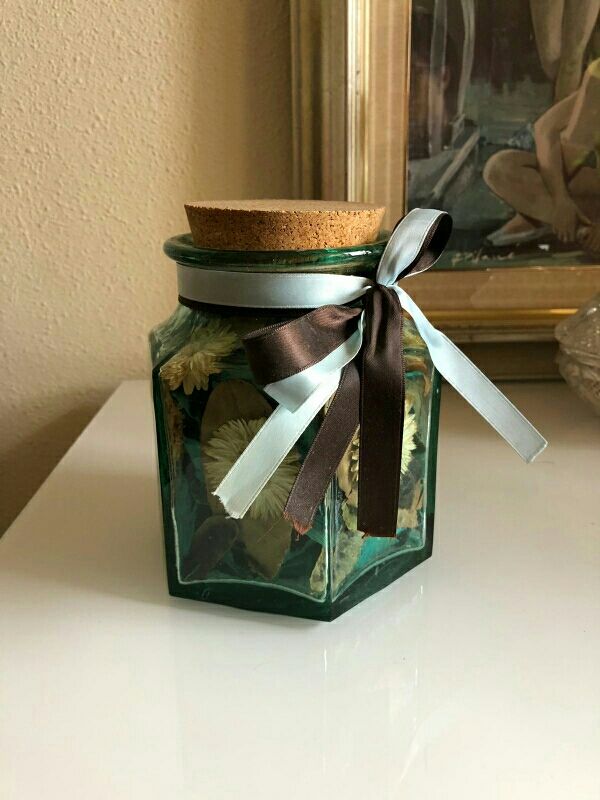 Tarro cristal azul con flores secas.