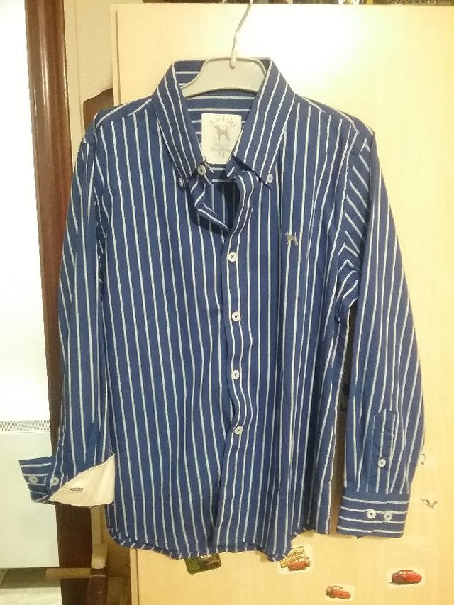 Camisa azul, con rayita fina vertical en blanco.