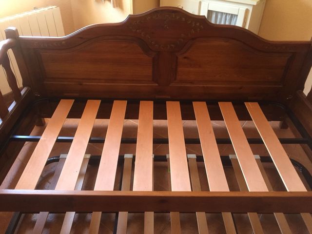 Letto in legno di pino tinto in ciliegio e decorato. Possibilità di una seconda rete sotto. Seminuovo.