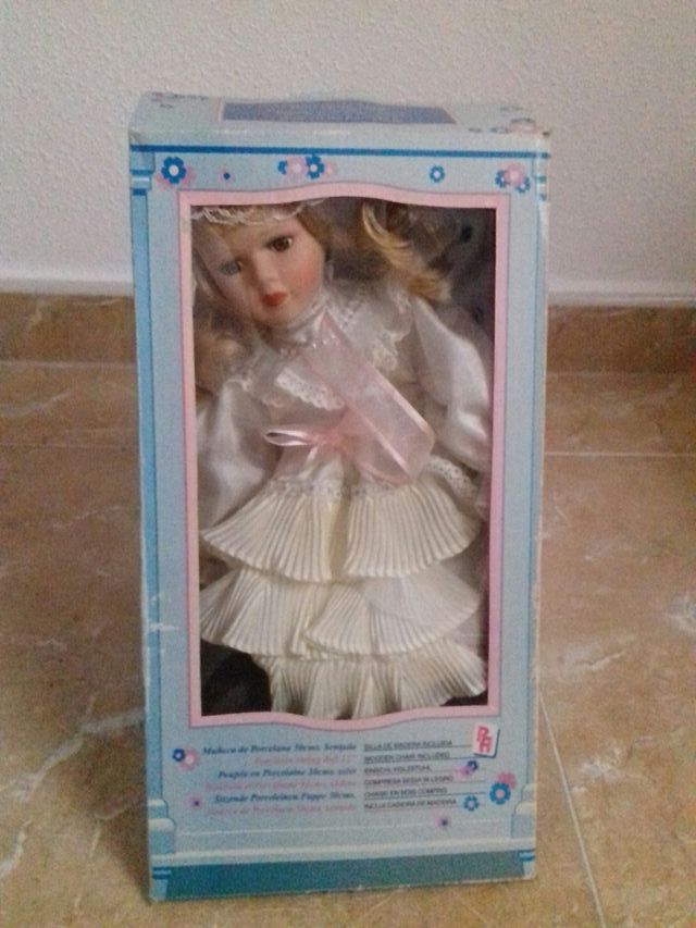 muñeca de porcelana con silla incluida