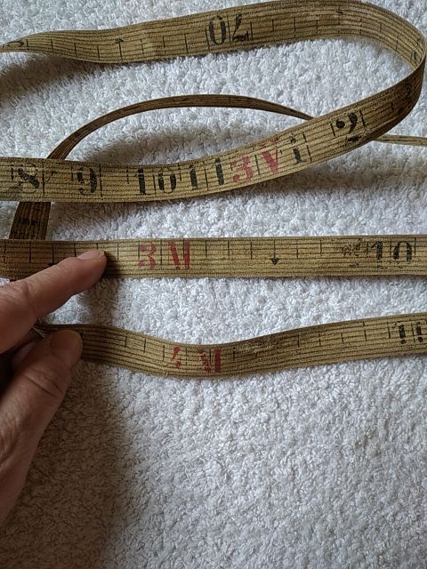 ANTIGUA CINTA MÉTRICA DE TELA, CUERO Y BRONCE.