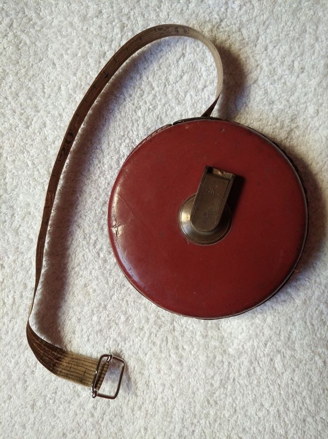 ANTIGUA CINTA MÉTRICA DE TELA, CUERO Y BRONCE.