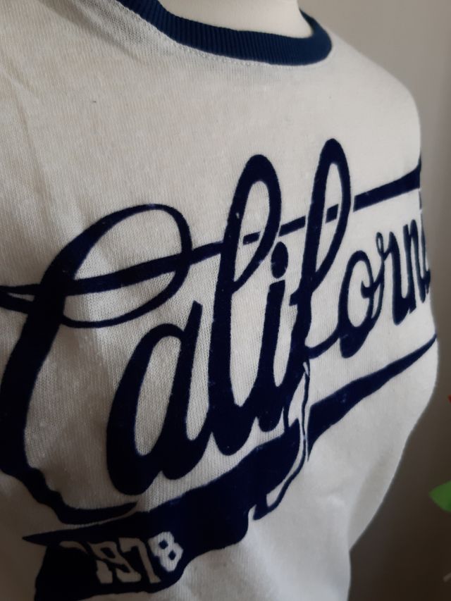 Camiseta blanca con letras azules en terciopelo