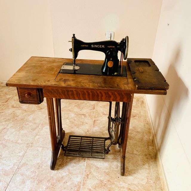 Mesa de madera con máquina de coser SINGER.