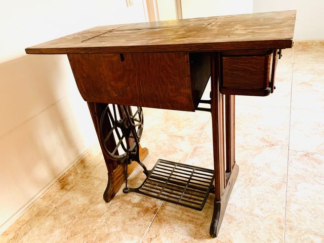 Mesa de madera con máquina de coser SINGER.