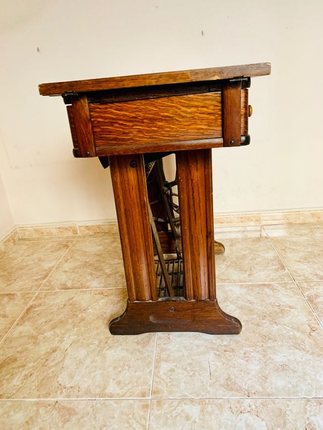 Mesa de madera con máquina de coser SINGER.