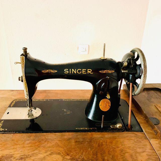 Mesa de madera con máquina de coser SINGER.