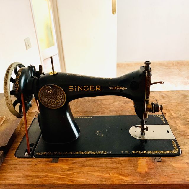 Mesa de madera con máquina de coser SINGER.