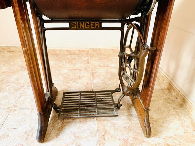 Mesa de madera con máquina de coser SINGER.