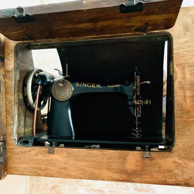 Mesa de madera con máquina de coser SINGER.