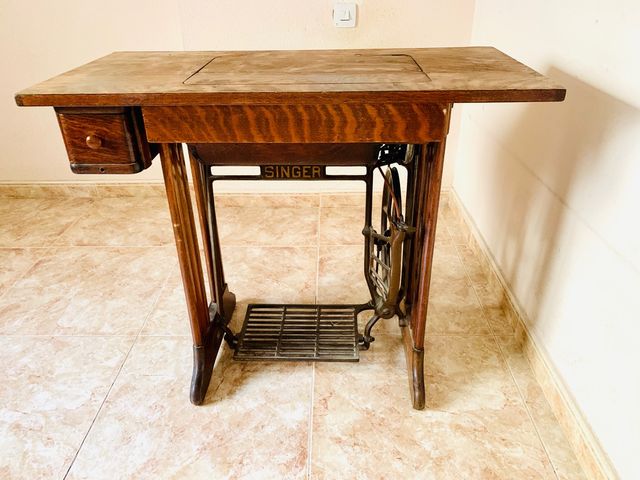 Mesa de madera con máquina de coser SINGER.