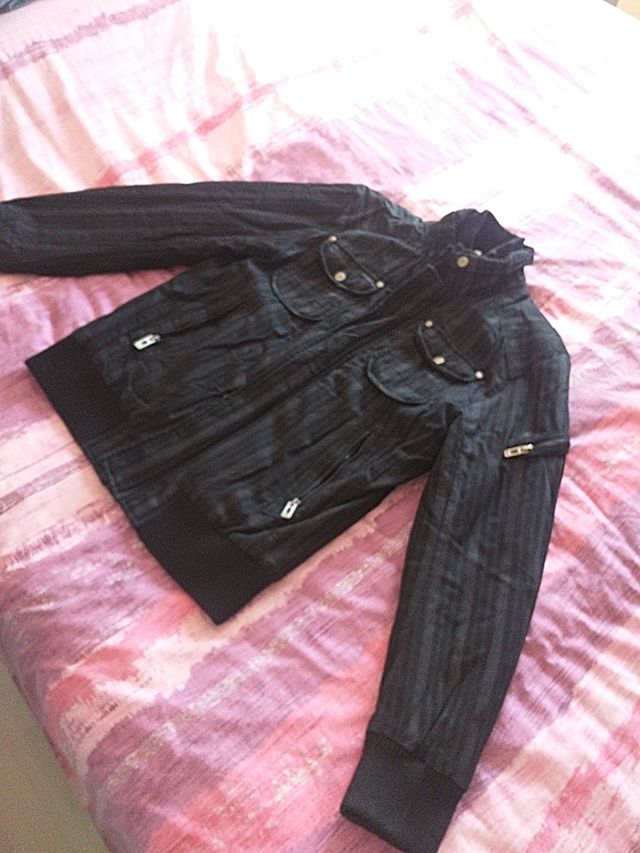 cazadora negra con rayas grises y morada bolsillos