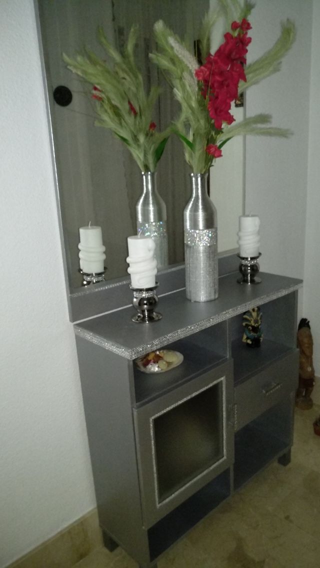 Mueble recibidor plateado.