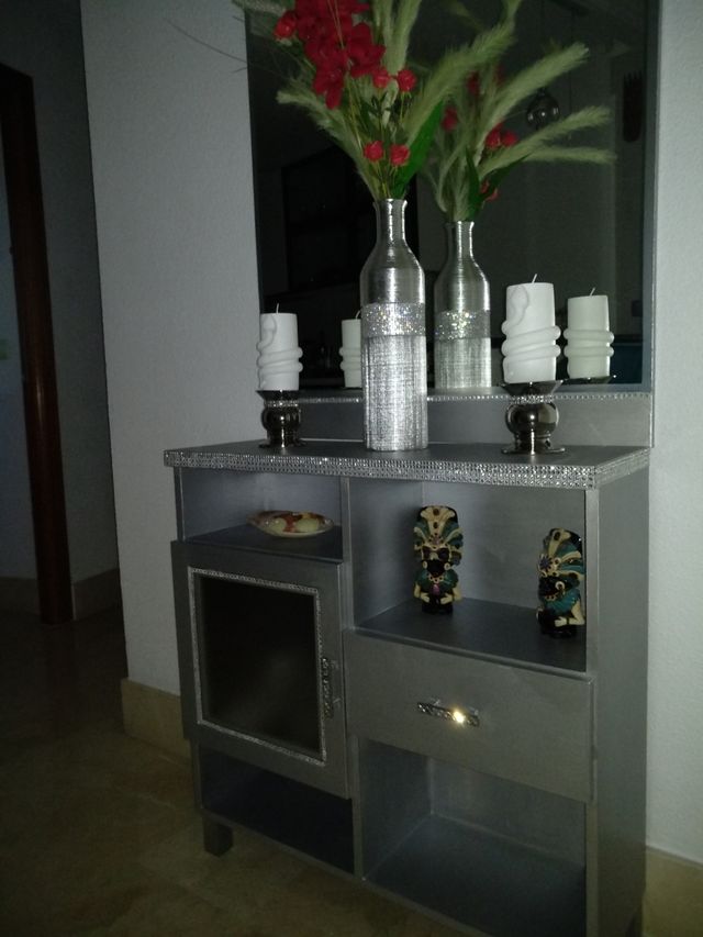 Mueble recibidor plateado.