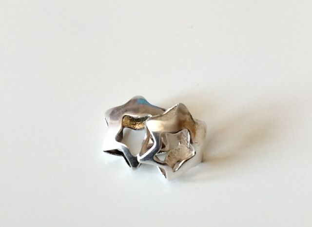 Colgante de plata tridimensional estrella y flor.