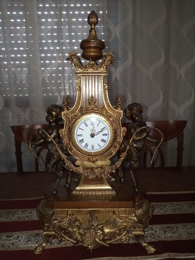 Reloj y candelabros de bronce, madera y mármol.
