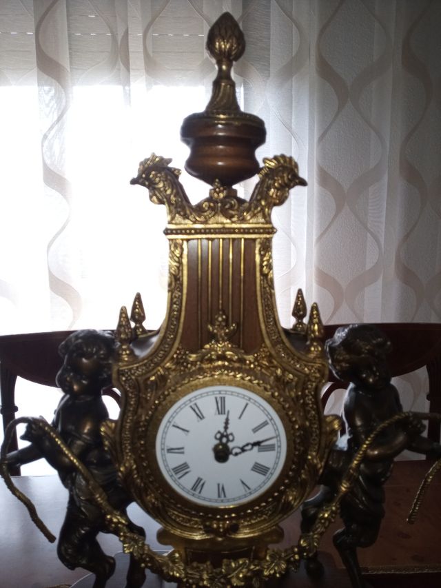 Reloj y candelabros de bronce, madera y mármol.