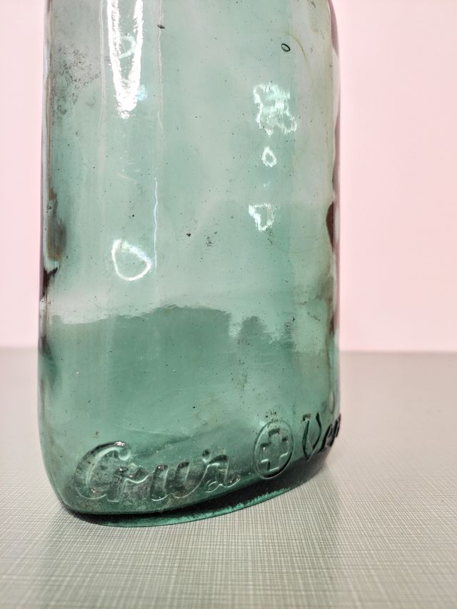 Botella cruz verde, vidrio soplado.