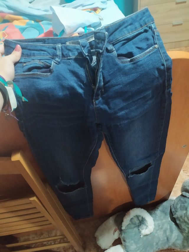 Vaqueros azules con rajas en las rodillas