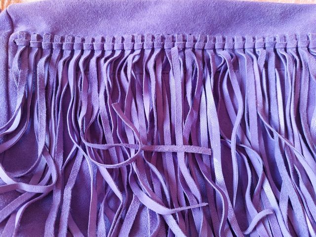 Bolso de flecos color morado.