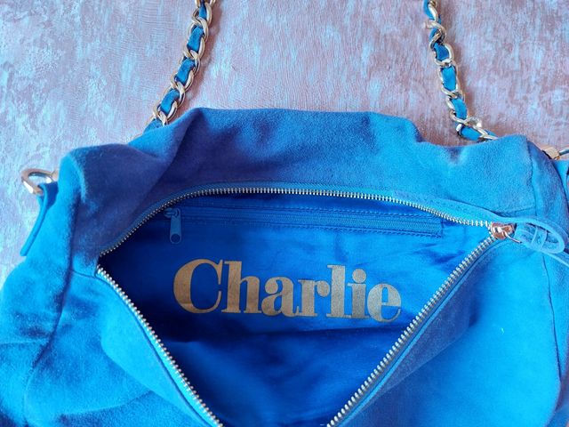 Bolso de flecos color morado.