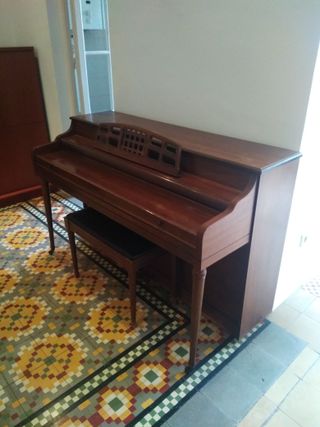 Piano de pared con banqueta en buen estado