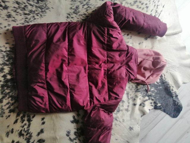 giacca in piuma viola bordeaux con cappello rosa.