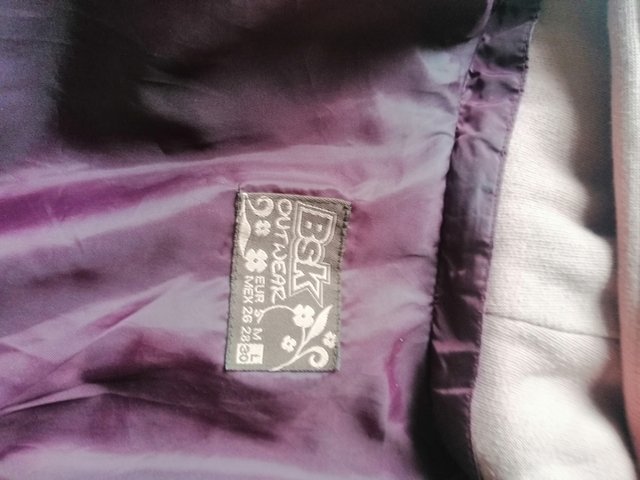 giacca in piuma viola bordeaux con cappello rosa.