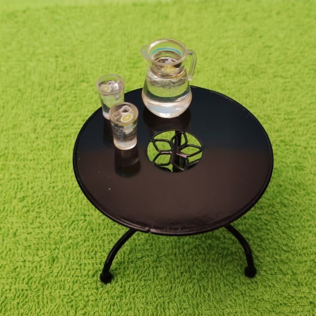 Escena muñecas porcelana en el jardín miniatura