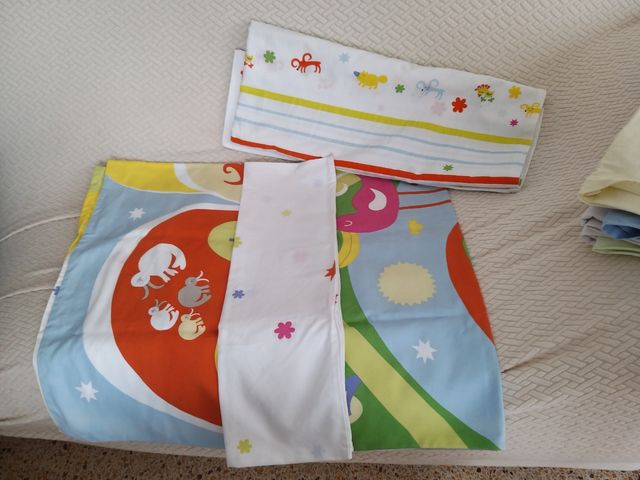 Cuna de madera y ajuar (ropa de cama).