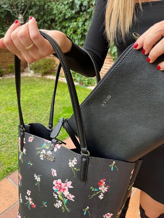 Bolso Guess negro con flores. Reversible de segunda mano por 100 EUR en  Madrid en WALLAPOP