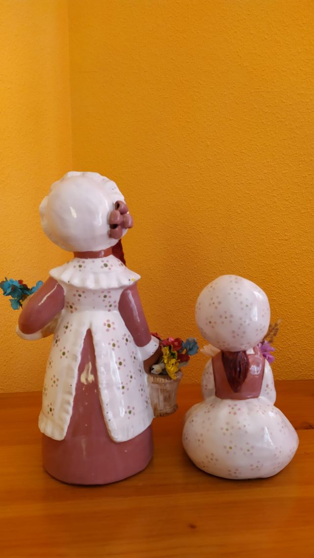 2 figuras de terracota, chicas con flores.