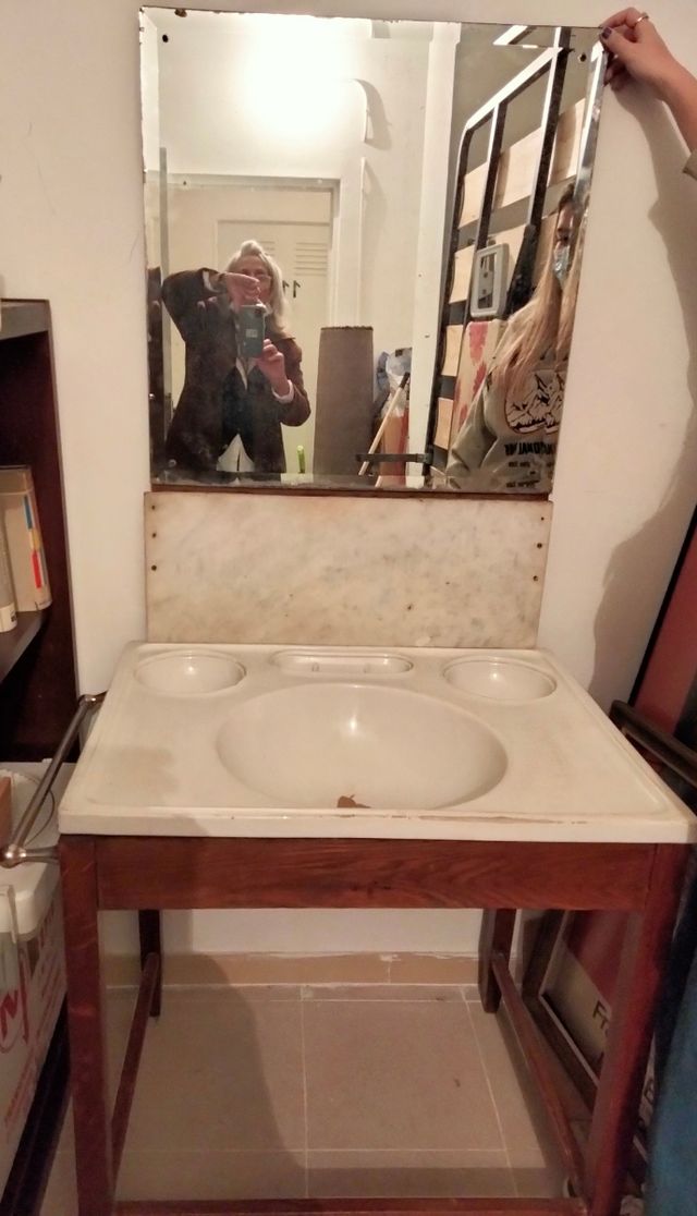 Lavabo antiguo con mueble y espejo.