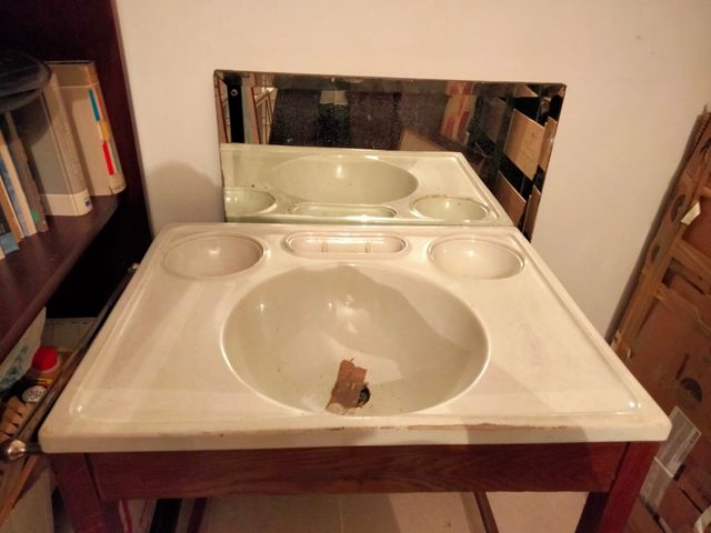 Lavabo antiguo con mueble y espejo.