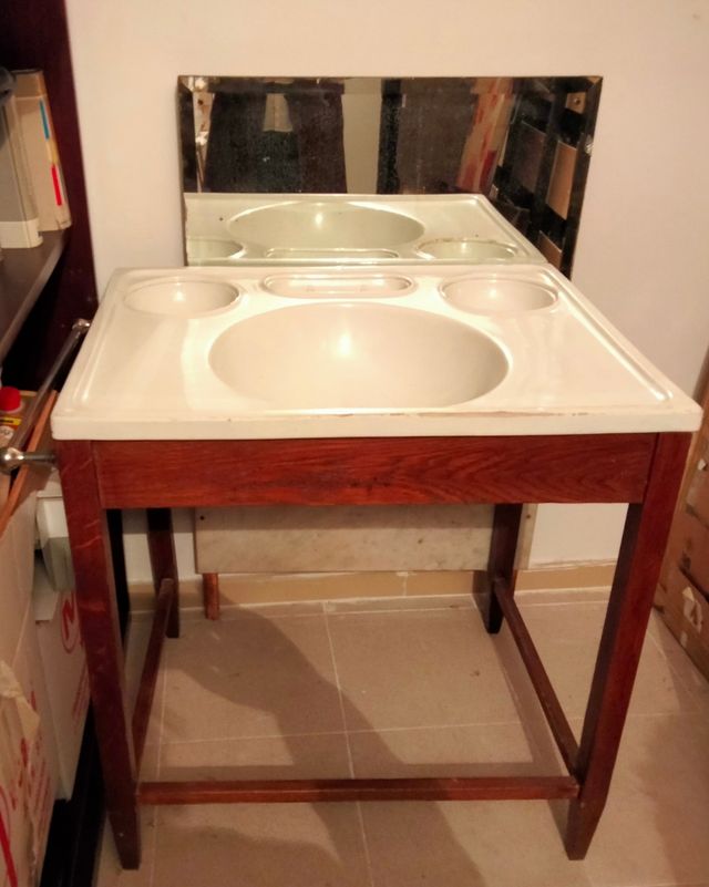 Lavabo antiguo con mueble y espejo.