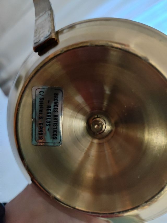 Candelabro portavelas de bronce con asa.