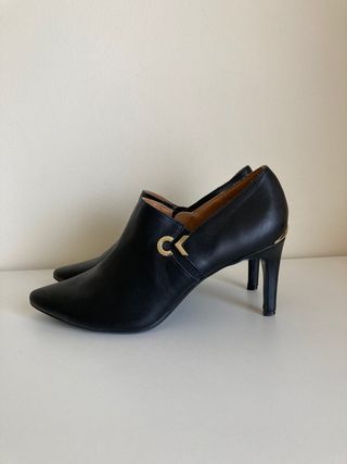 Botines Calvin Klein negros con logo dorado de segunda mano por 15 EUR en  Barcelona en WALLAPOP