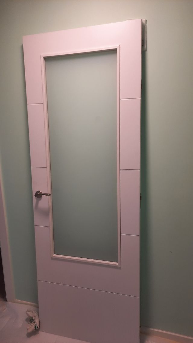 Puerta blanca de madera con cristalera