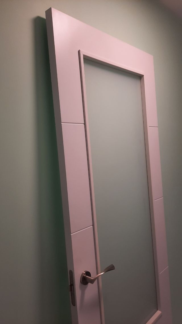 Puerta blanca de madera con cristalera