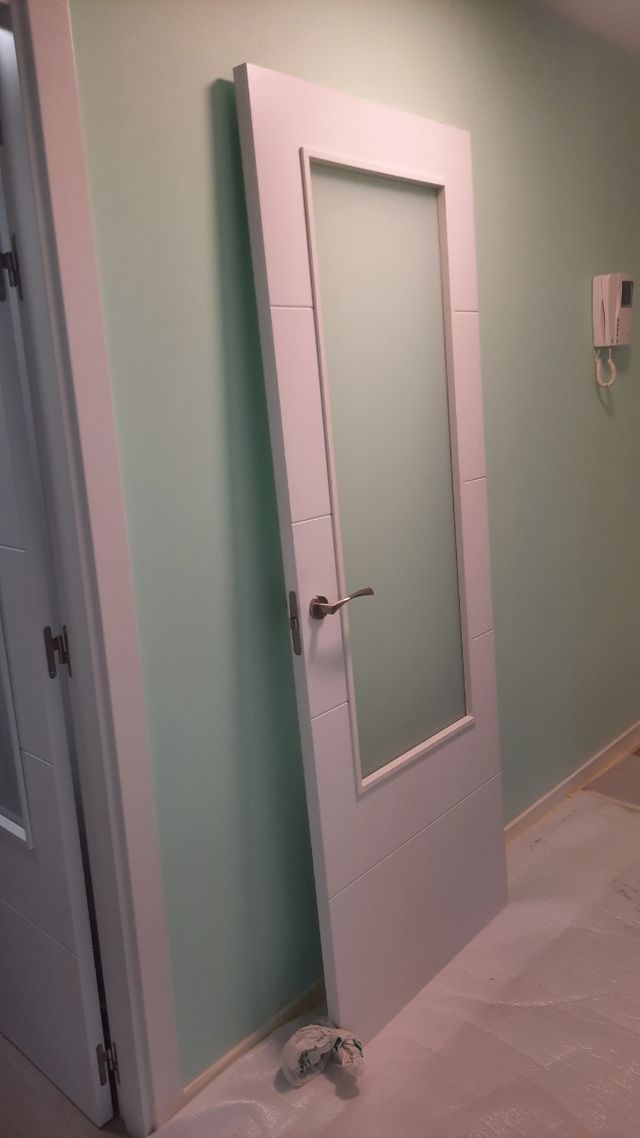 Puerta blanca de madera con cristalera