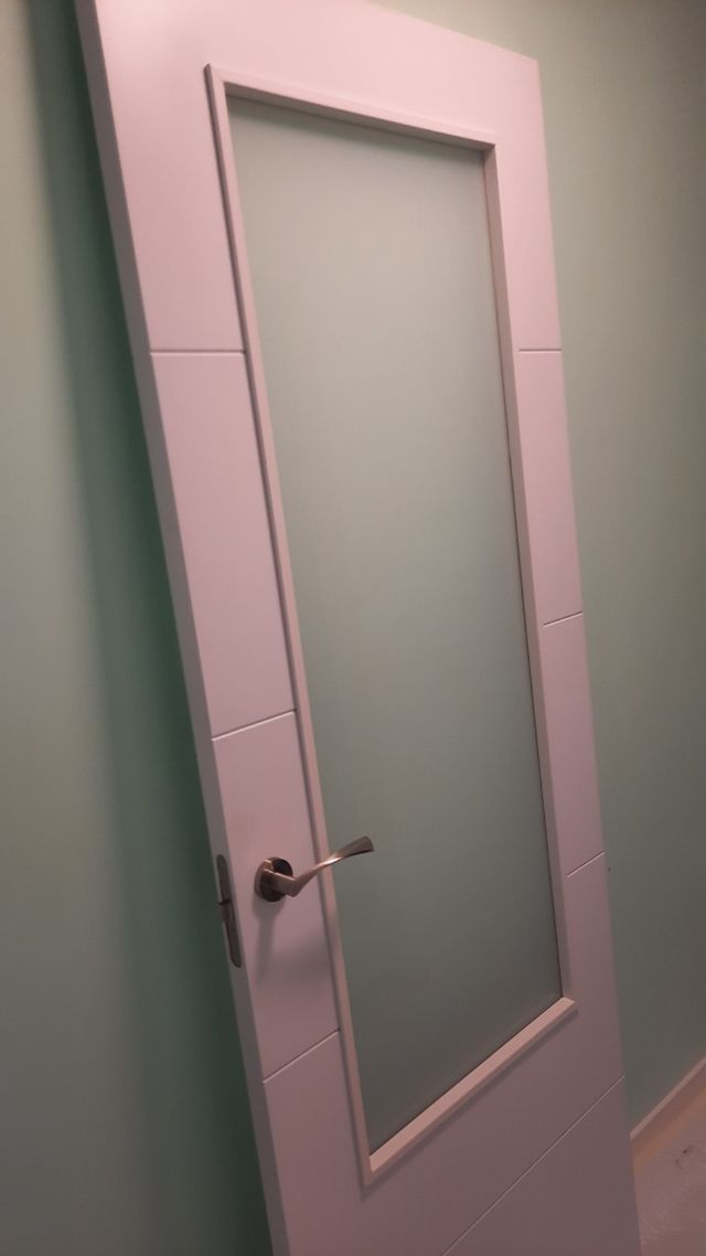 Puerta blanca de madera con cristalera