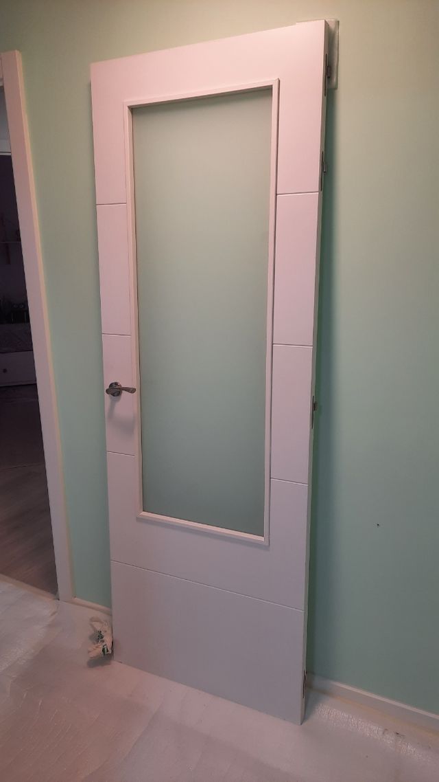 Puerta blanca de madera con cristalera