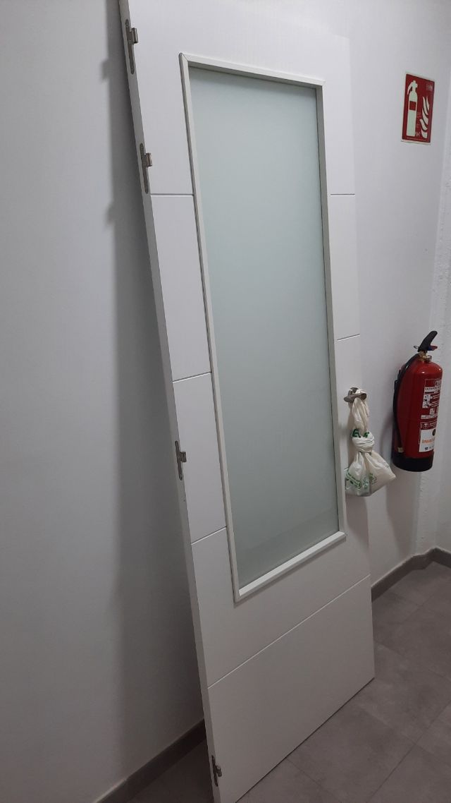 Puerta blanca de madera con cristalera