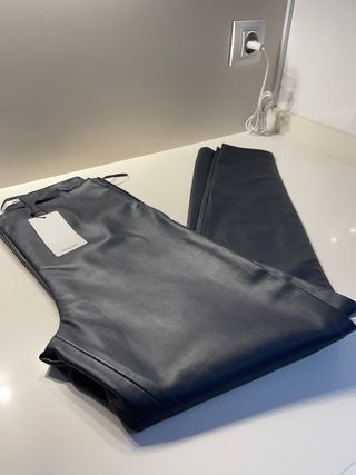 Pantalón polipiel tobillero Mango con etiqueta de segunda mano por 15 EUR  en O Porriño en WALLAPOP