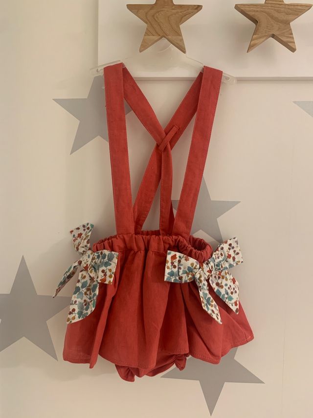 Falda-cubrepañal con tirantes color coral