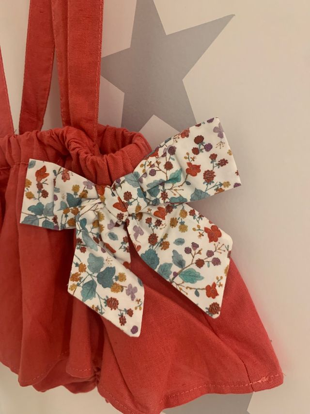 Falda-cubrepañal con tirantes color coral