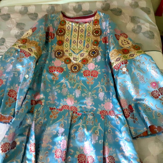 Túnica en brocado azul y pedrería.