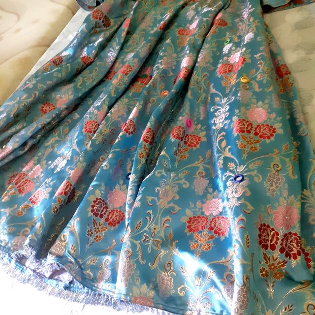 Túnica en brocado azul y pedrería.